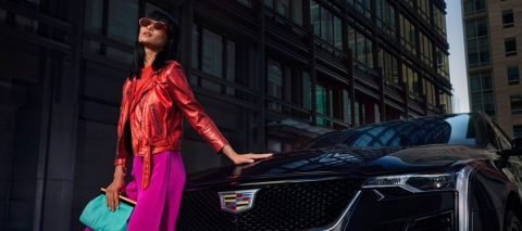 Stylish woman poses in front of Cadillac