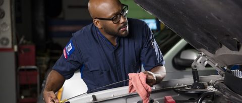 A man performing car care in a garage