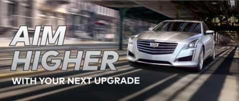Cadillac sedan speeding along a highway with text overlay “Aim Higher With Your Next Upgrade”