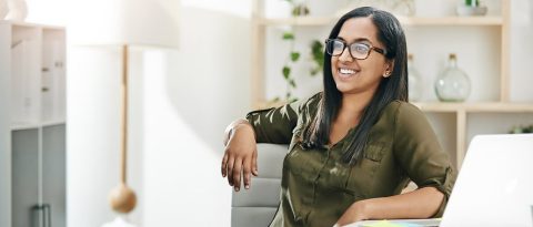 woman confidently smiling in front of a computer