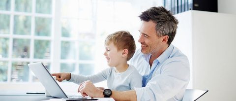 father with child looking at a computer