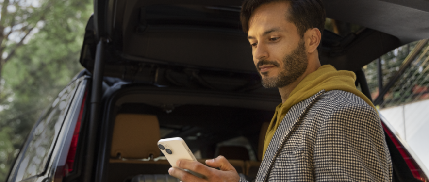 Man outside SUV accessing MyAccount from his smartphone.